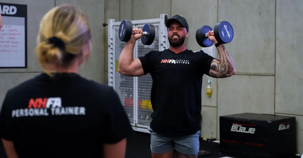 Personal trainer coaching client during one-on-one session in Australian gym